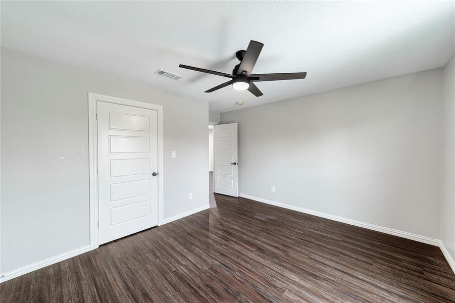 Unfurnished bedroom with dark wood finished floors, ceiling fan, and a closet