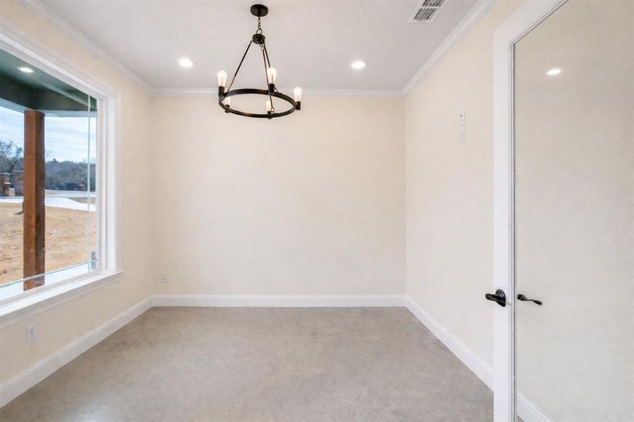 Unfurnished room featuring crown molding, light colored carpet, and hanging lights Unfurnished room featuring crown molding, light colored carpet, and hanging lights