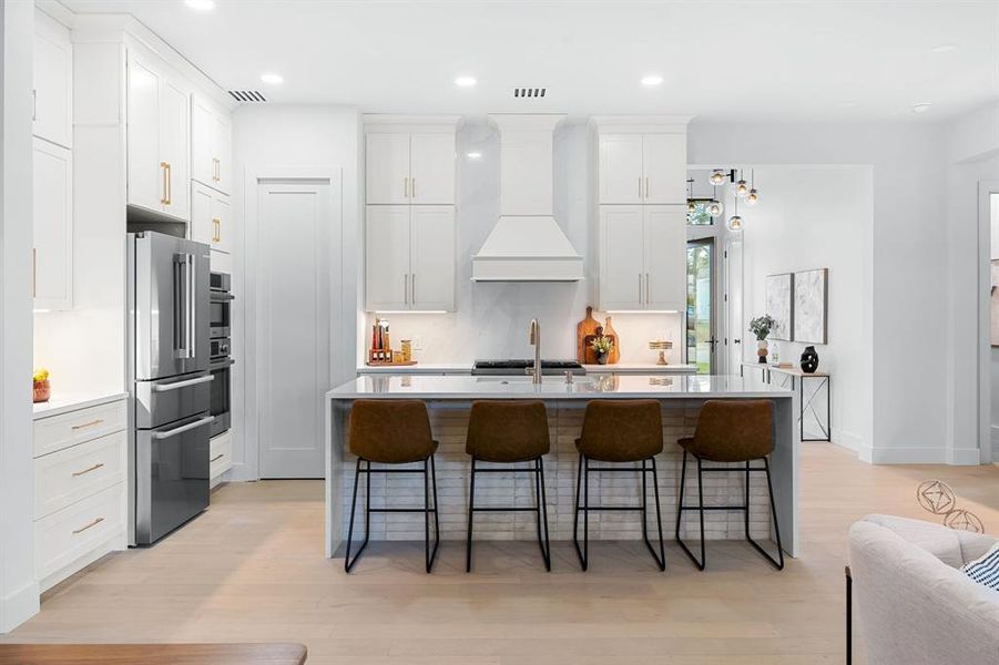 Fabuwood cabinetry, stylish hardware, Moen and Delta faucets, quartz countertops, and an oversized center island with waterfall countertops make this a culinary masterpiece