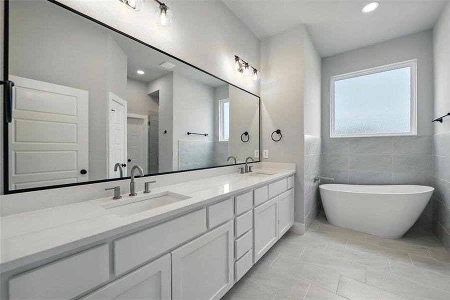 Bathroom featuring double vanity, a freestanding tub, tiled shower, and recessed lighting Bathroom featuring double vanity, a freestanding tub, tiled shower, and recessed lighting