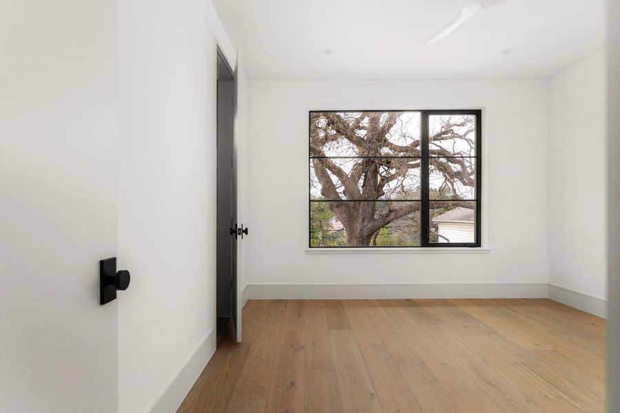 Spare room featuring light wood-type flooring and baseboards
