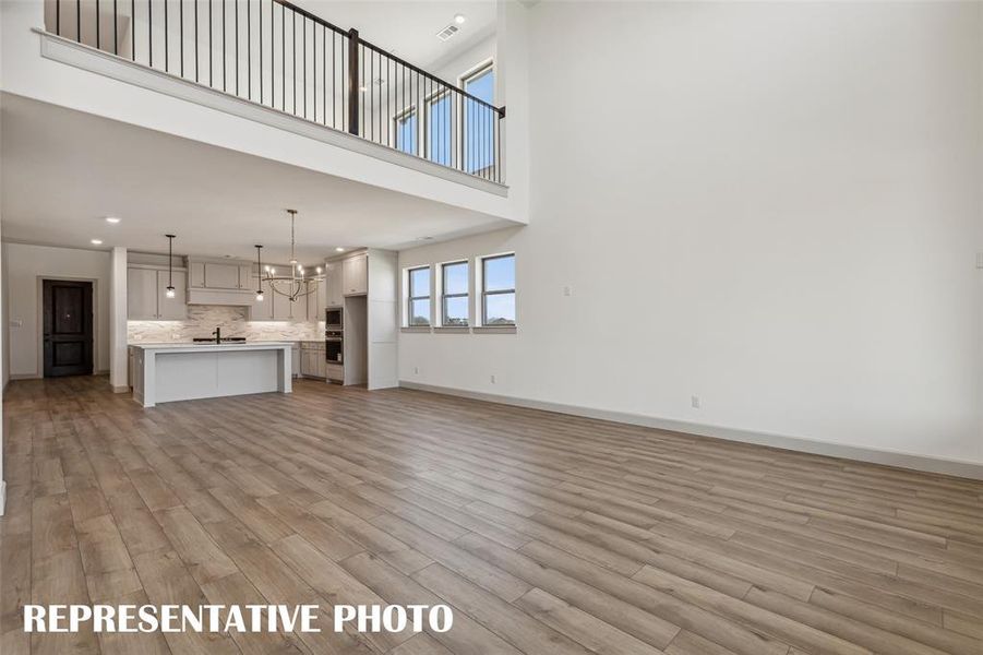 With the family room open to the game room above, you'll enjoy multi-level entertaining in this dream home!  REPRESENTATIVE PHOTO