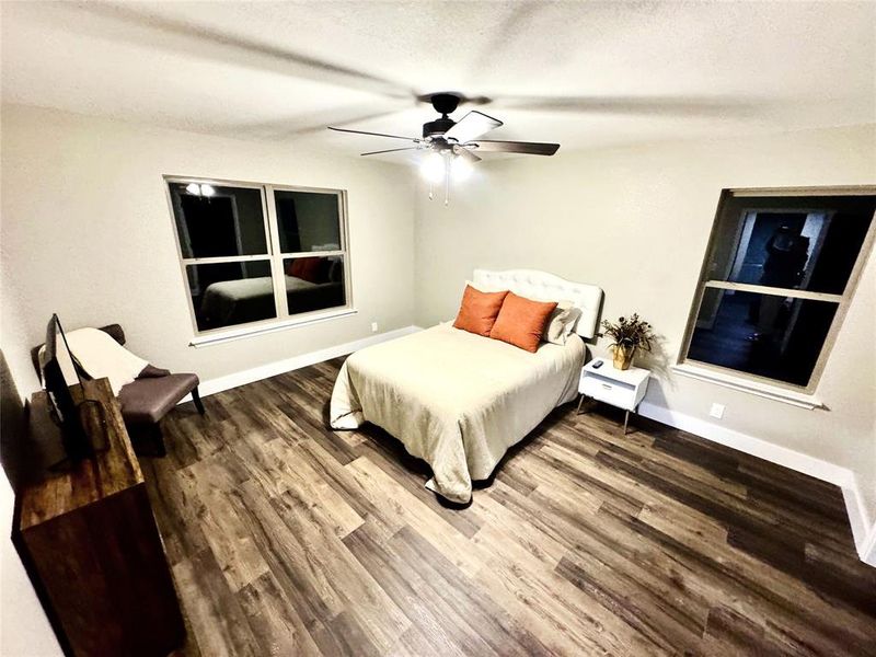 Bedroom featuring wood finished floors, a ceiling fan, and a textured ceiling