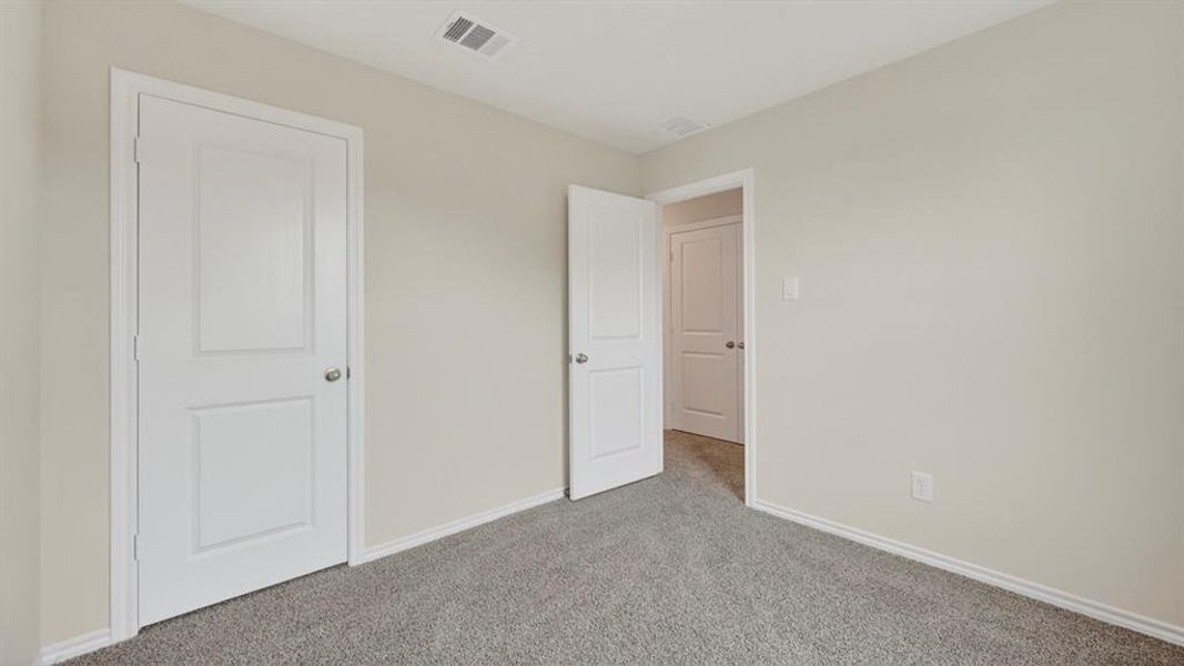 Neutral-toned room featuring a gray carpeted floor and white baseboards