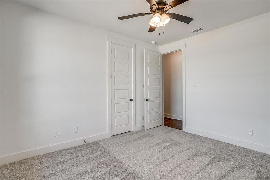 Unfurnished bedroom featuring carpet flooring and ceiling fan