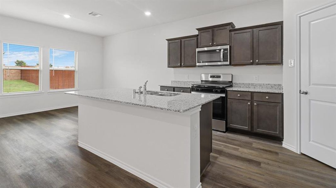 Kitchen island featuring a double basin sink and a stone-finish countertop Kitchen island featuring a double basin sink and a stone-finish countertop