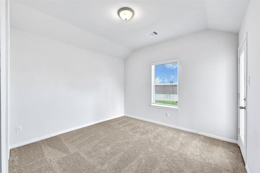This bright, neutral-toned bedroom features plush carpet, a single window with blinds, and a ceiling light, offering a cozy and inviting space.Please note: The image is not the actual home; it is a home with the same floor plan in the neighborhood.