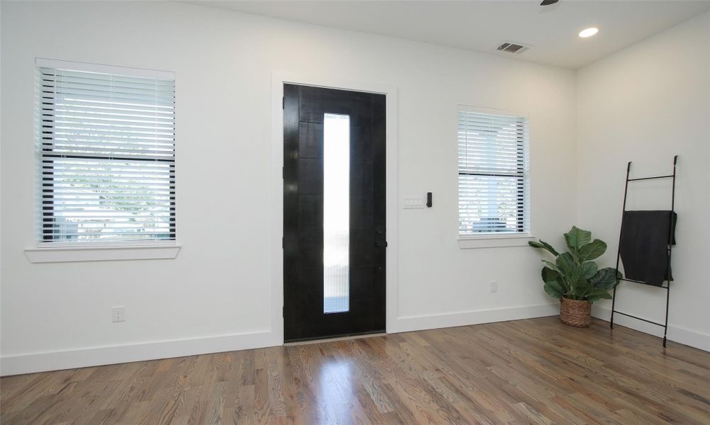 View toward the modern front door from the kitchen showcasing the abundant natural light. View toward the modern front door from the kitchen showcasing the abundant natural light.