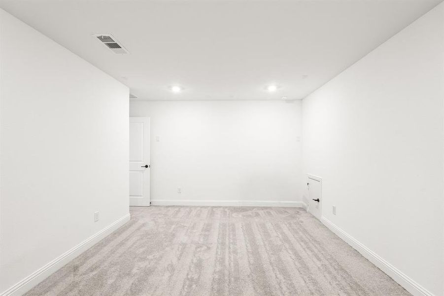 Spare room with light carpet and baseboards
