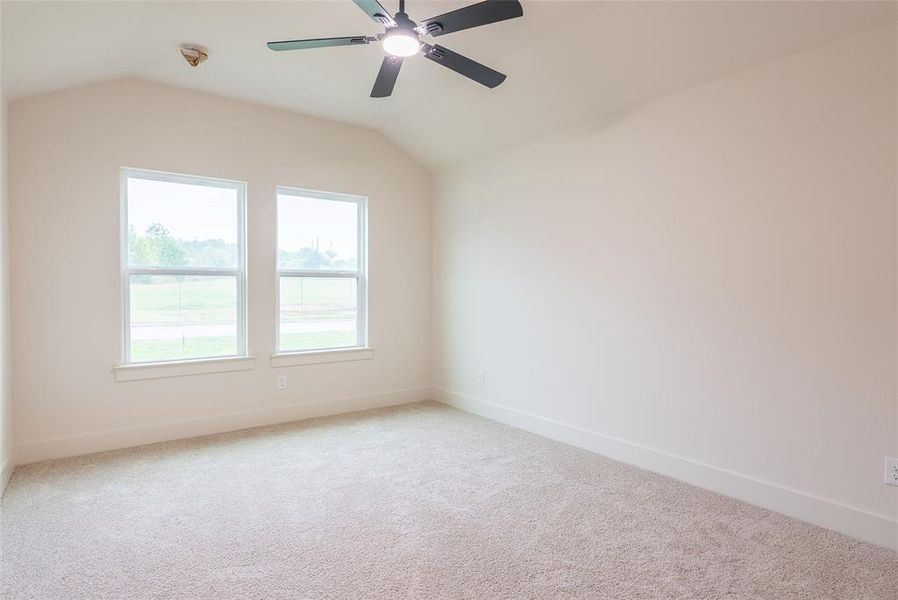 Spare room with lofted ceiling, light colored carpet, and ceiling fan