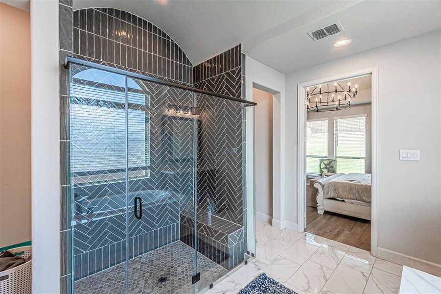 Walk-in shower featuring herringbone and subway tile, glass enclosure, and integrated bench