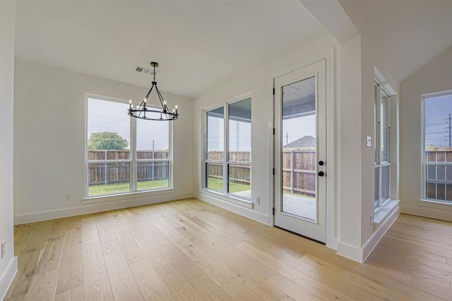 Unfurnished dining area with light wood finished floors and a chandelier Unfurnished dining area with light wood finished floors and a chandelier