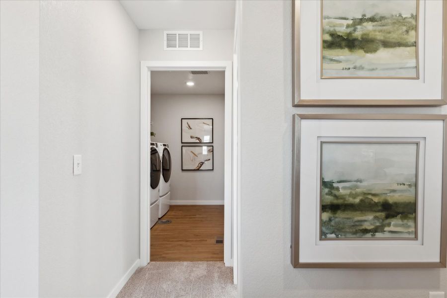 A room with a mirror and a shelf with pictures on it. A room with a mirror and a shelf with pictures on it.