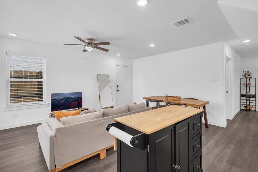 The room is bright, with white walls and LVP this is looking back from the kitchen to show entrance to the main entrance. The sleek flooring, and bright cheerful kitchen creating a welcoming atmosphere. The room is bright, with white walls and LVP this is looking back from the kitchen to show entrance to the main entrance. The sleek flooring, and bright cheerful kitchen creating a welcoming atmosphere.