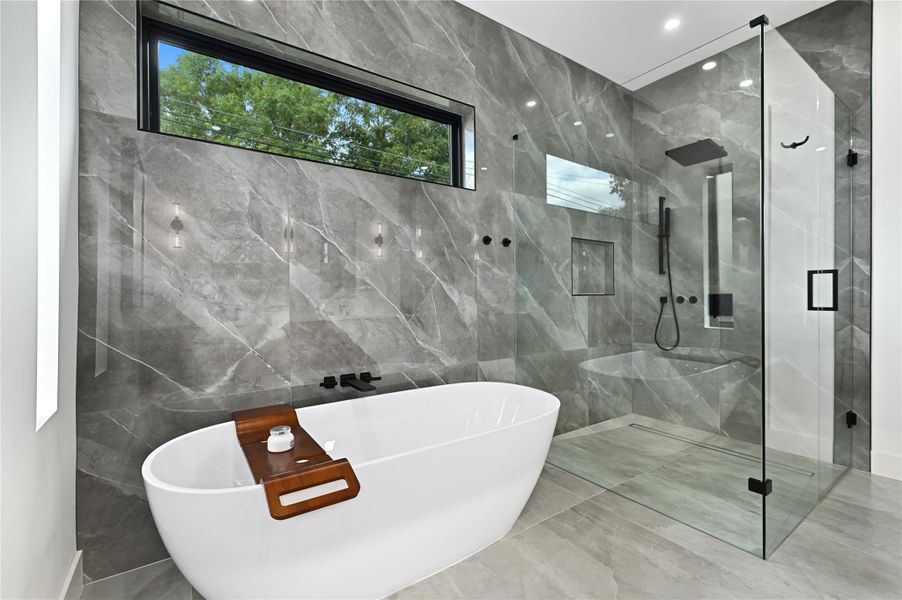 Full bathroom featuring a shower stall, tile walls, and a freestanding tub