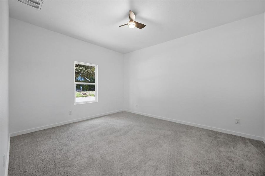 Spare room featuring light carpet and a ceiling fan Spare room featuring light carpet and a ceiling fan