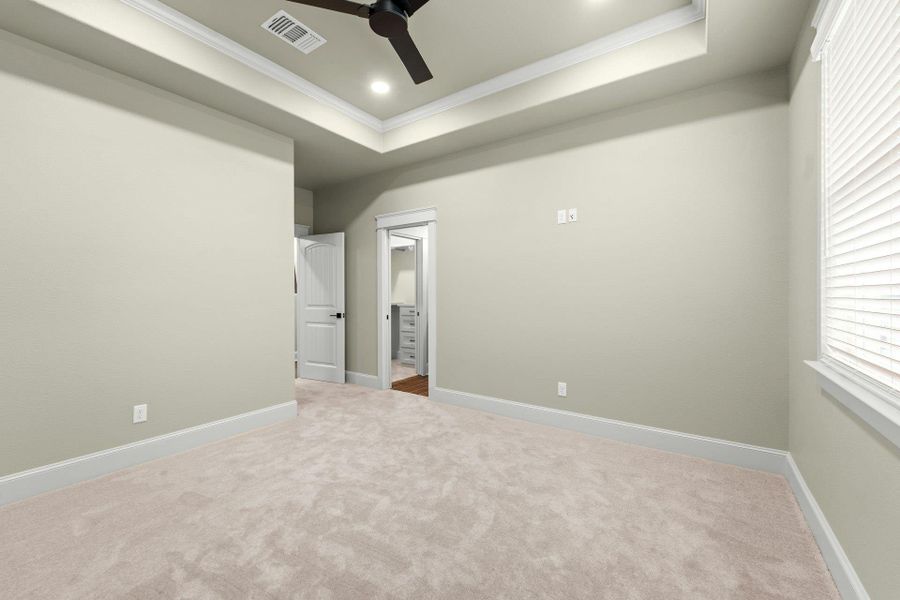 Carpeted room featuring a tray ceiling with recessed lighting and a ceiling fan
