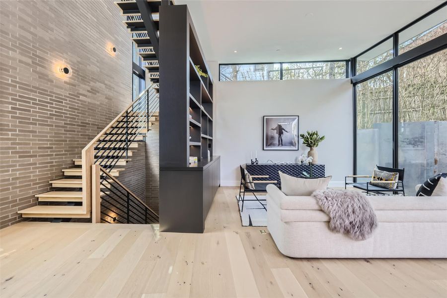 Blonde hardwood floors complement a sleek, open staircase and expansive living area, creating an airy ambiance. Blonde hardwood floors complement a sleek, open staircase and expansive living area, creating an airy ambiance.