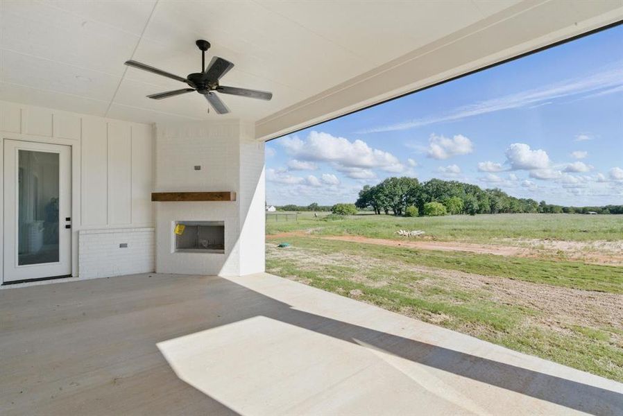 View of patio with a fireplace, a ceiling fan, and a view of rural / pastoral area View of patio with a fireplace, a ceiling fan, and a view of rural / pastoral area