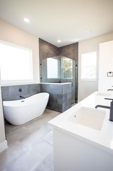 Bathroom with double vanity, a soaking tub, a shower stall, tile walls, and recessed lighting Bathroom with double vanity, a soaking tub, a shower stall, tile walls, and recessed lighting