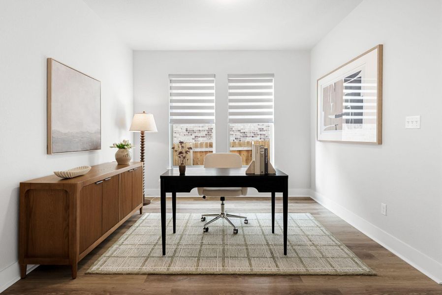 Well-lit private office featuring warm hardwood flooring and crisp white walls.