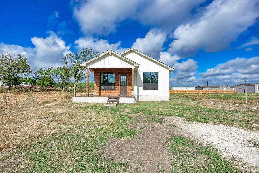 A charming covered front porch highlights the exterior of this modern board and batten home.