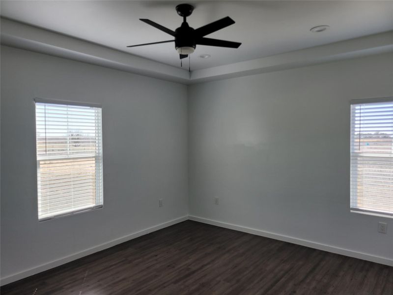 A quiet bedroom showcases a contemporary ceiling fan and rich wood flooring. A quiet bedroom showcases a contemporary ceiling fan and rich wood flooring.