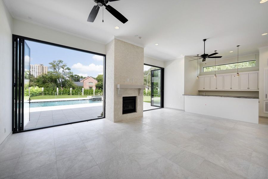 Incredible indoor/outdoor living room with fireplace and summer kitchen. Doors open to the pool and patio area.