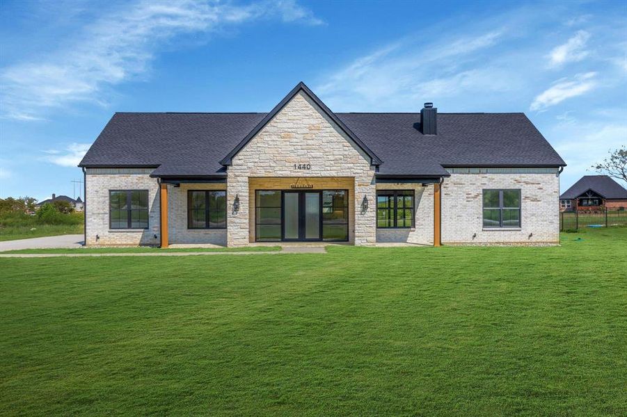 Front of the house with porch, stone and brick facade.