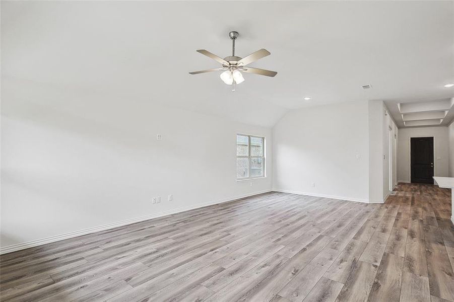 Unfurnished room featuring light hardwood / wood-style flooring, ceiling fan, and vaulted ceiling