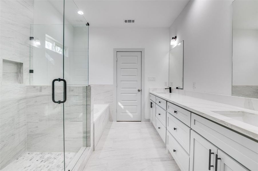 Bathroom featuring visible vents, double vanity, a stall shower, a bath, and marble finish floor