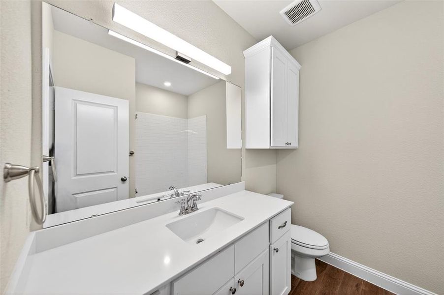 Bathroom featuring a vanity with an integrated sink, polished chrome faucet, and white countertop