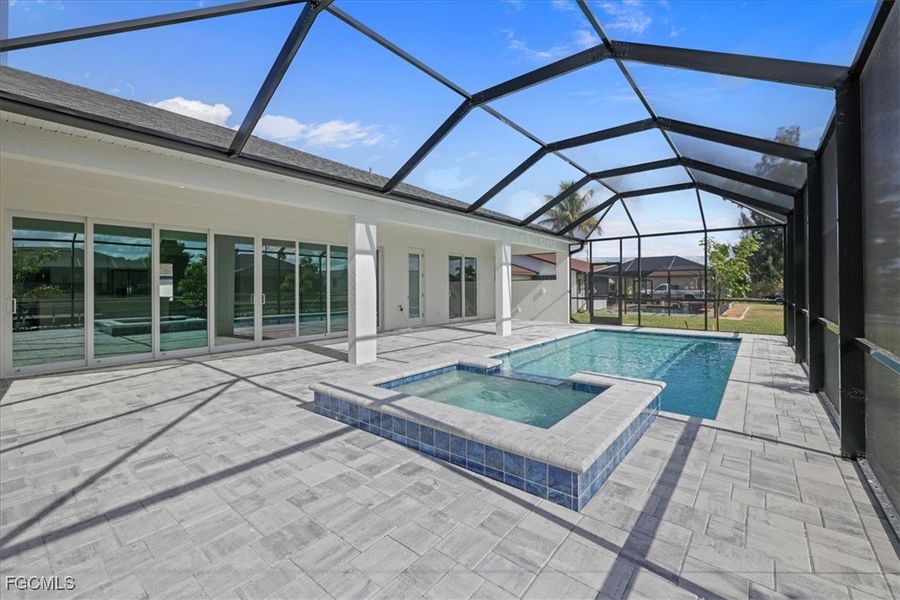 View of pool with a sunroom, a pool with connected hot tub, a patio area, and a lanai