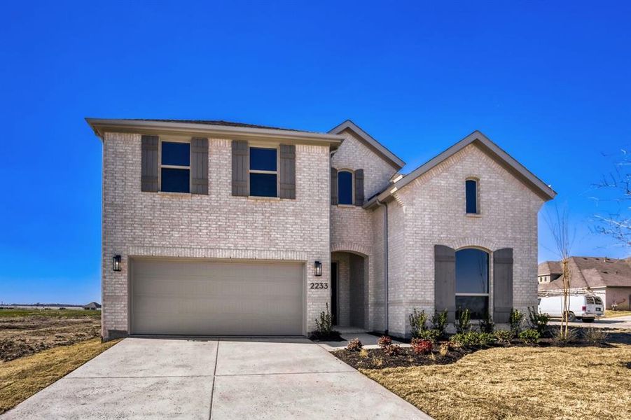 View of front of house featuring brick siding, concrete driveway, and a garage