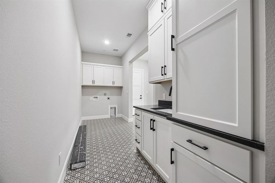 Laundry area with hookup for an electric dryer, washer hookup, cabinet space, and recessed lighting Laundry area with hookup for an electric dryer, washer hookup, cabinet space, and recessed lighting