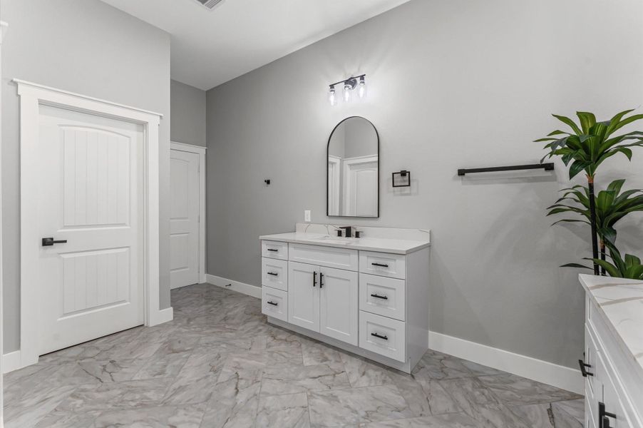 Dual vanities with quartz countertops and modern fixtures create a spa-like experience. Dual vanities with quartz countertops and modern fixtures create a spa-like experience.