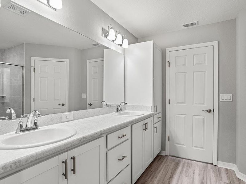 Your suite is complete with a dual-vanity en-suite bath with a linen cabinet - Ashlyn by Highland Homes