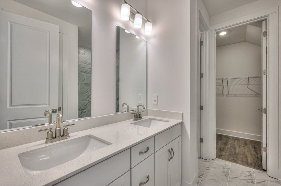 The primary bathroom offers dual vanity sinks and a walk-in shower.