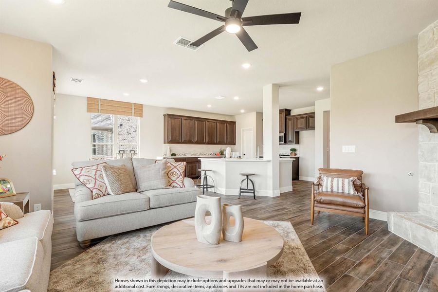 Open living room with ceiling fan and hardwood floors, open to kitchen with dark wood cabinets Open living room with ceiling fan and hardwood floors, open to kitchen with dark wood cabinets