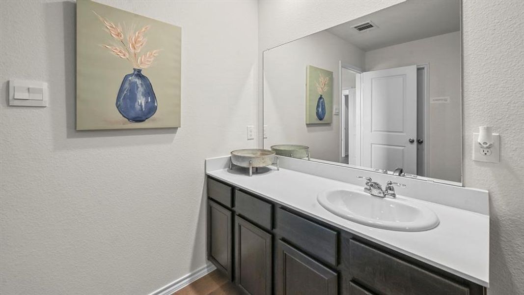 Bathroom with a textured wall and vanity