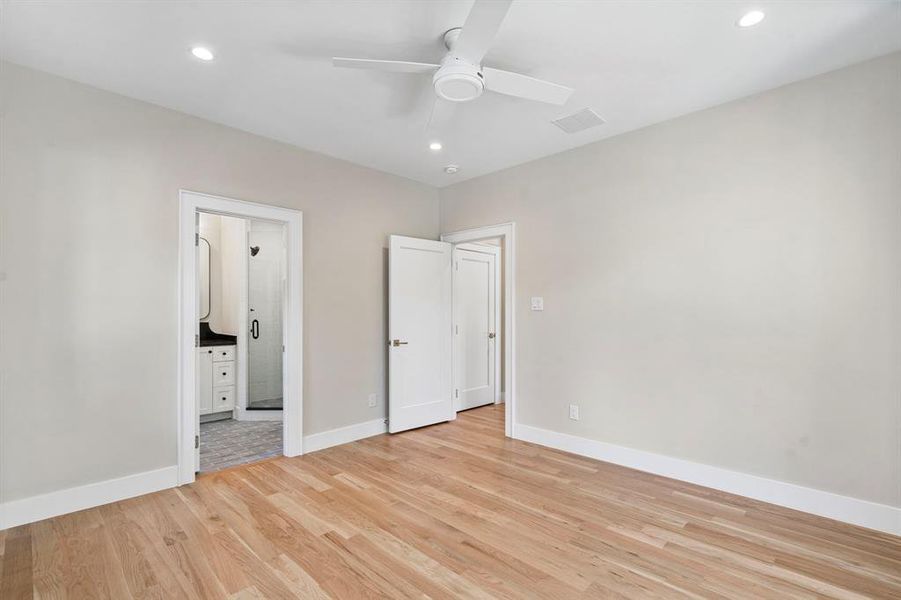 Unfurnished bedroom featuring light hardwood / wood-style flooring, connected bathroom, and ceiling fan