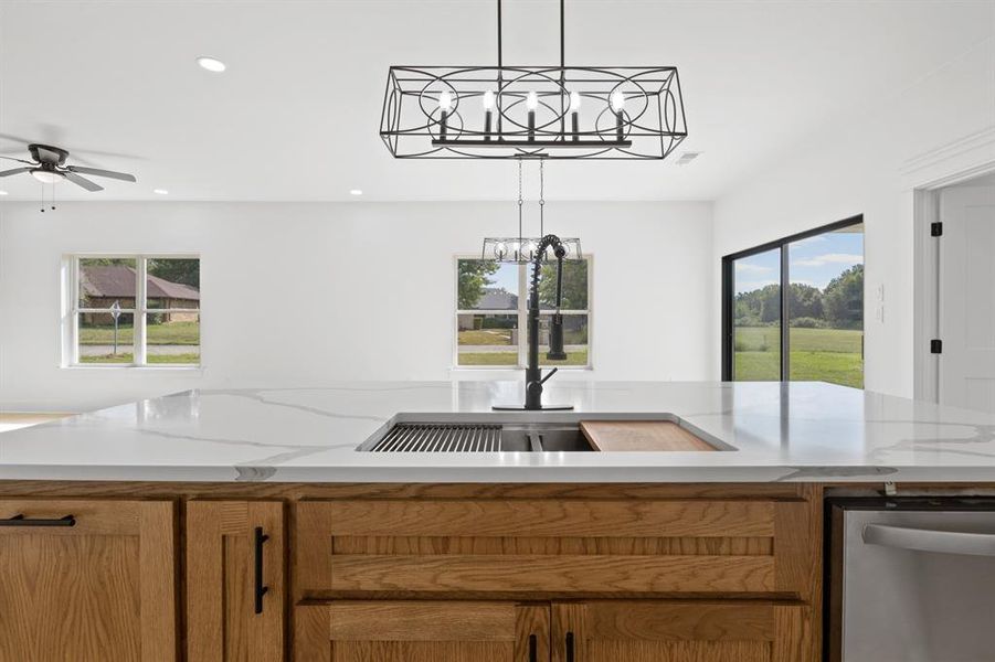 Kitchen with stainless steel dishwasher, pendant lighting, brown cabinetry, recessed lighting, and a ceiling fan
