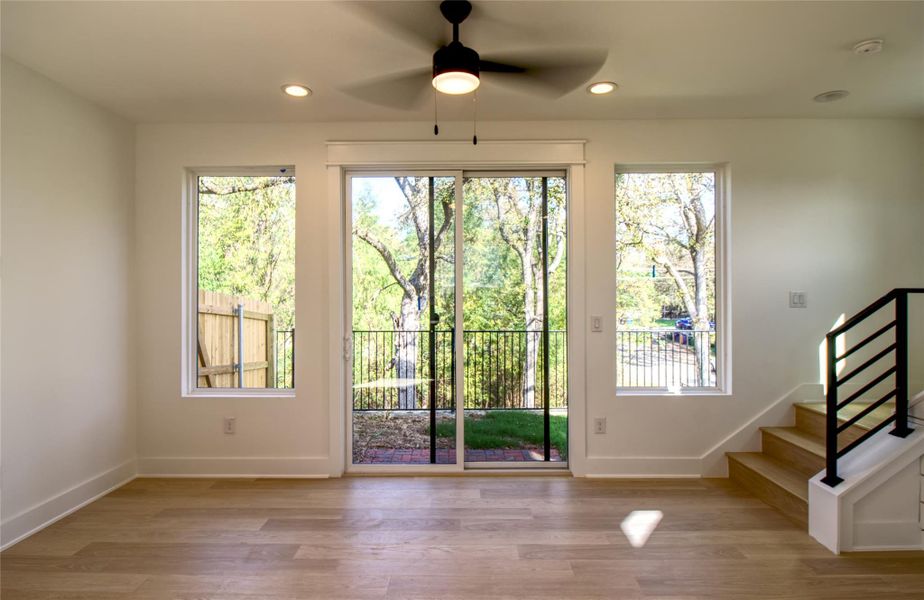 Sliding glass door to outside with a ceiling fan, wood finished floors, stairway, and recessed lighting Sliding glass door to outside with a ceiling fan, wood finished floors, stairway, and recessed lighting
