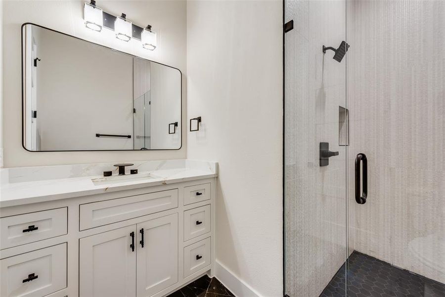 Bathroom with a shower stall, vanity, and baseboards Bathroom with a shower stall, vanity, and baseboards