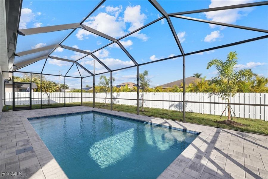 View of swimming pool featuring a fenced backyard, a sunroom, glass enclosure, and a patio area View of swimming pool featuring a fenced backyard, a sunroom, glass enclosure, and a patio area