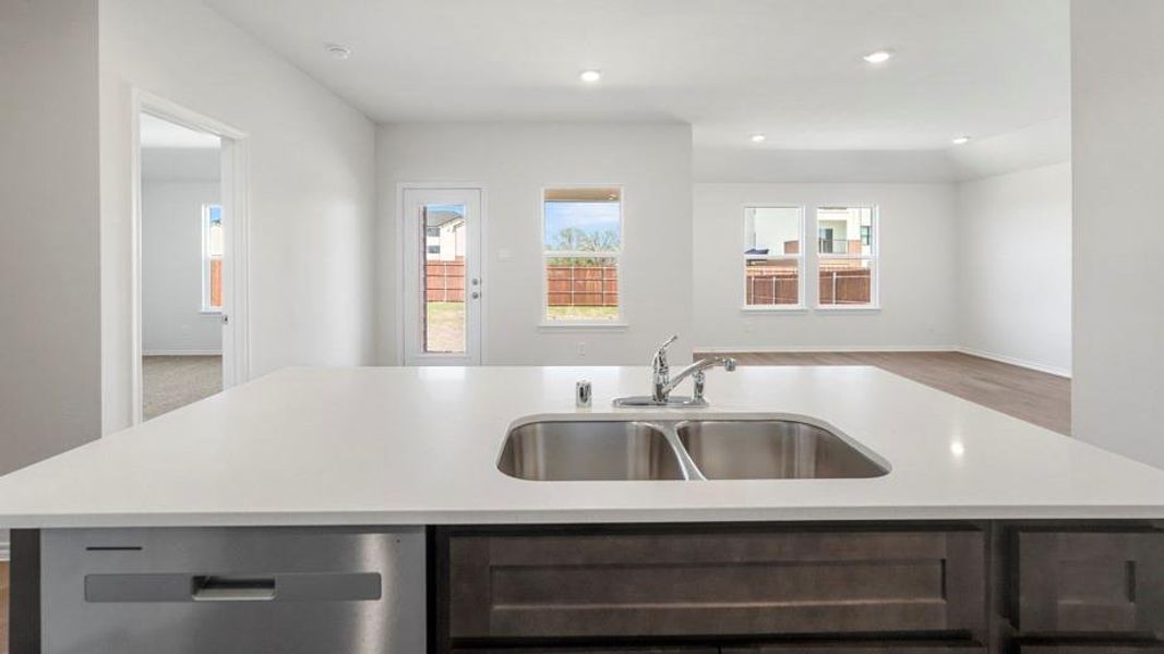 Kitchen island featuring a double basin stainless steel sink, chrome faucet, and integrated dishwasher Kitchen island featuring a double basin stainless steel sink, chrome faucet, and integrated dishwasher