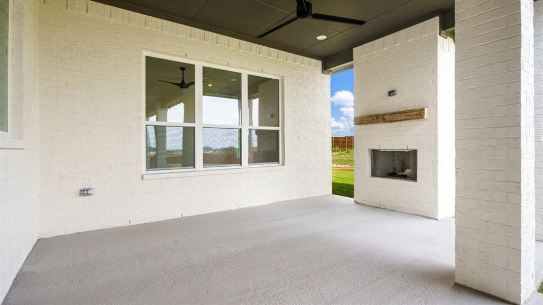 View of patio / terrace featuring ceiling fan and an outdoor brick fireplace