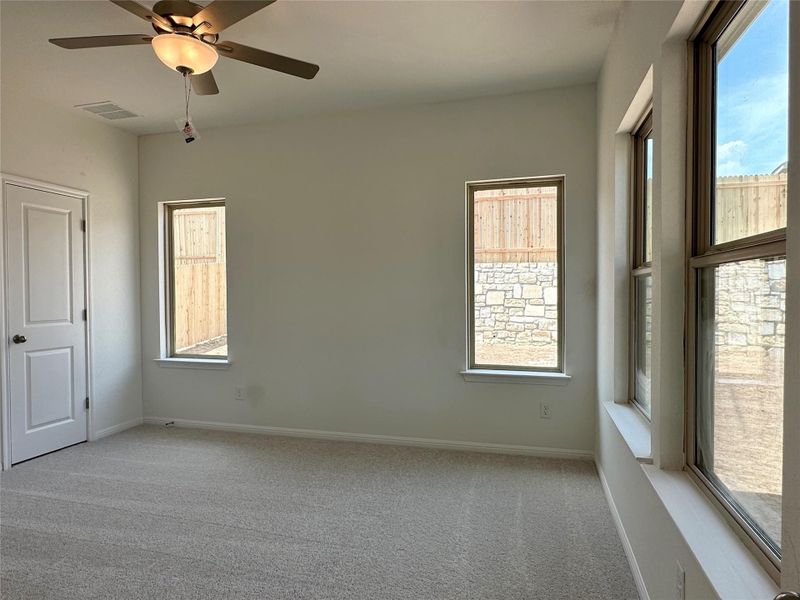 Unfurnished room with light colored carpet and a ceiling fan