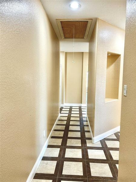 Hall featuring dark tile patterned floors