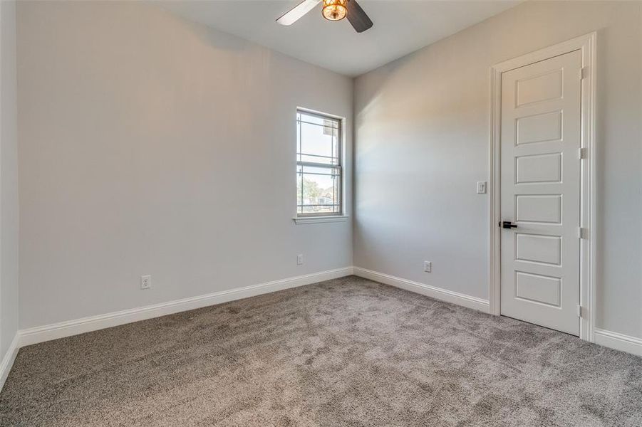 Carpeted empty room with ceiling fan